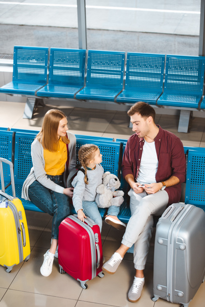 vue aérienne du père parlant avec sa fille près des valises et sa femme dans le salon de départ
 - Photo, image