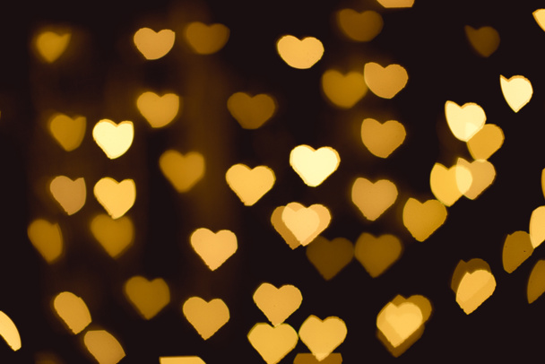 yellow heart shaped bokeh lights on black backdrop - Photo, Image