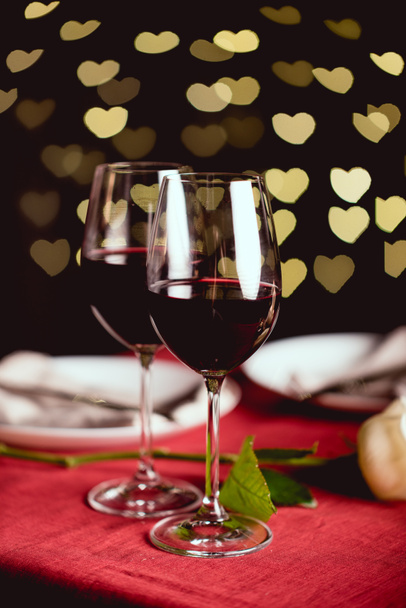 επιλεκτική εστίαση του ποτήρια κόκκινο κρασί με σχήμα καρδιάς bokeh στο παρασκήνιο - Φωτογραφία, εικόνα