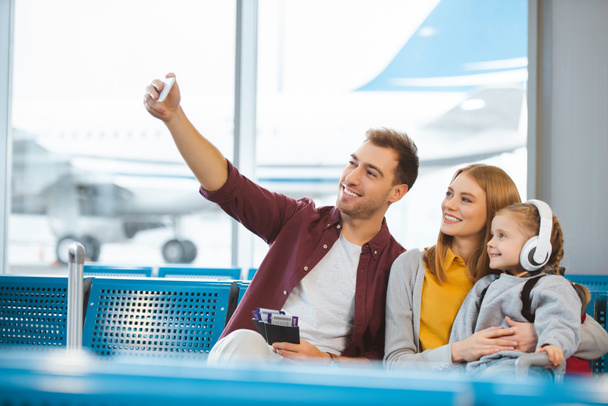 happy family taking selfie and smiling in departure lounge - Фото, зображення