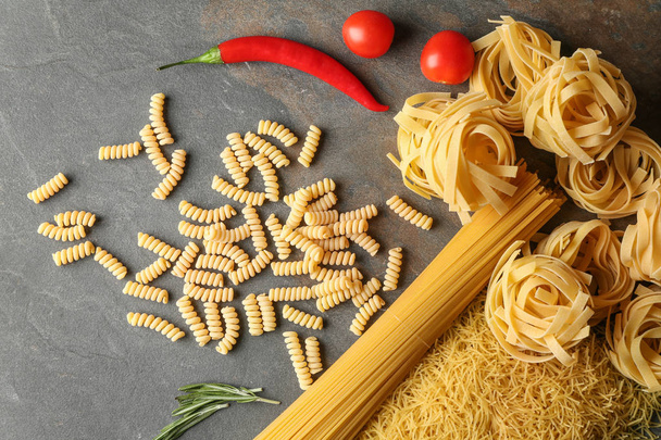 Assortment of uncooked pasta on grey table - Photo, Image