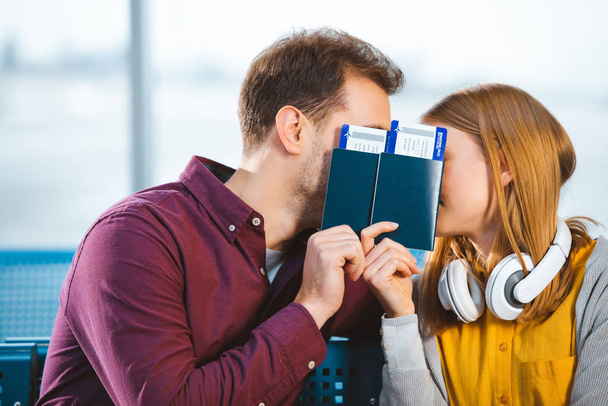 copain et copine couvrant les visages avec des passeports à l'aéroport
 - Photo, image