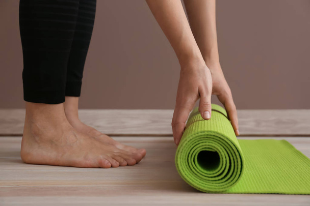 Jeune femme sportive avec tapis de yoga en salle de gym
 - Photo, image