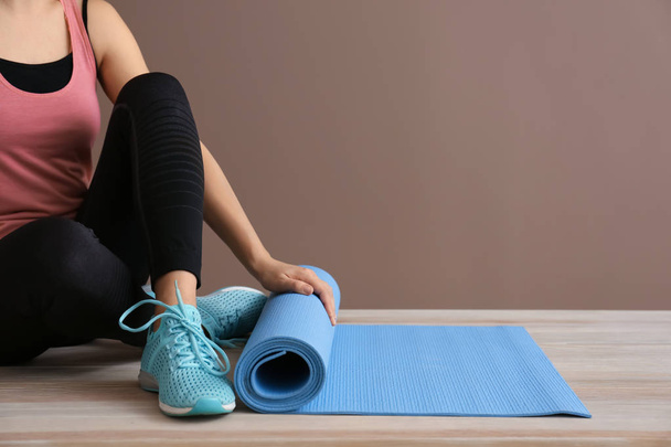 Молода спортивна жінка з йоги килимок у спортзалі
 - Фото, зображення