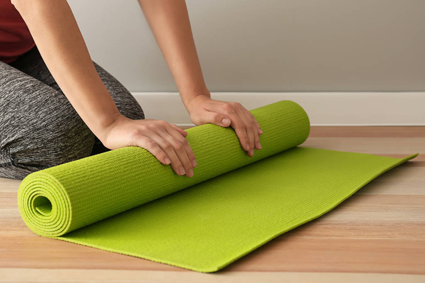 Jovem mulher esportiva com tapete de ioga no ginásio
 - Foto, Imagem