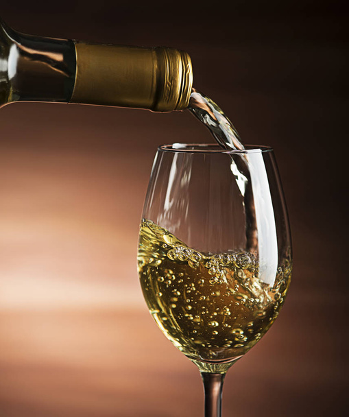 White wine pouring into wine glass, close-up - Image - Foto, afbeelding