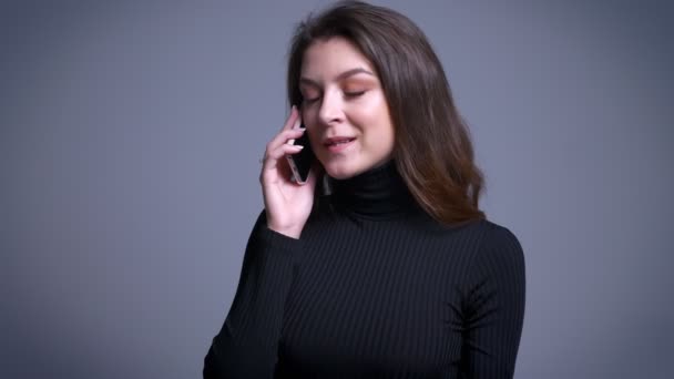 Closeup portrait of attractive modern caucasian female casually talking on the phone and smiling - Video, Çekim