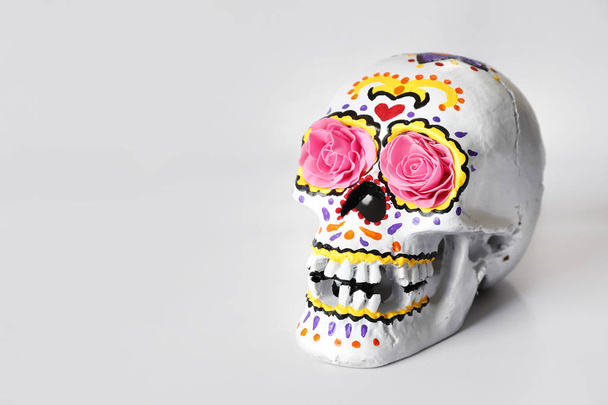 Раскрашенный человеческий череп к Дню мертвых в Мексике на белом фоне
 - Фото, изображение
