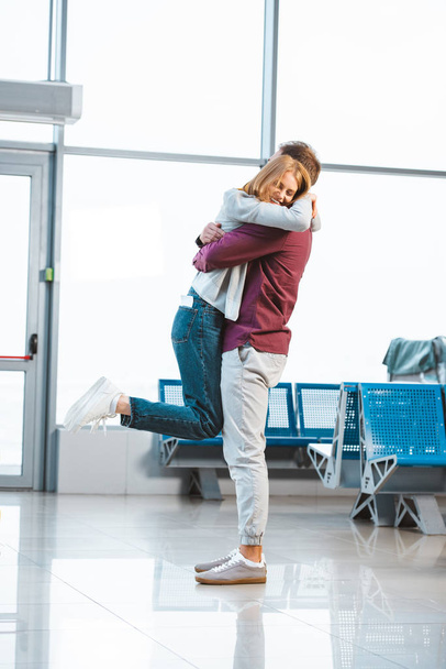 femme heureuse étreignant petit ami à l'aéroport
  - Photo, image