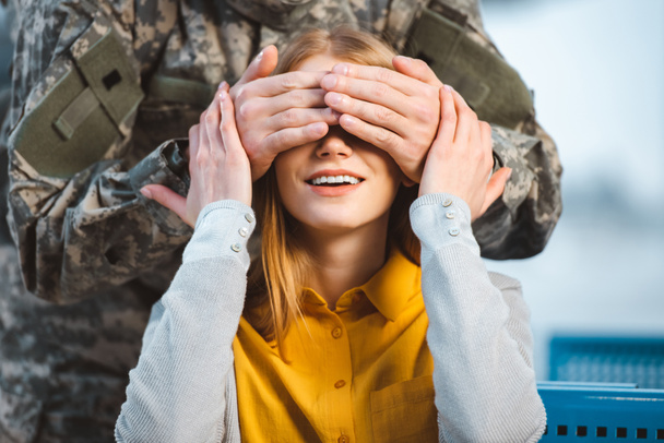 cropped view of veteran closing eyes of cheerful girlfriend  - Фото, изображение