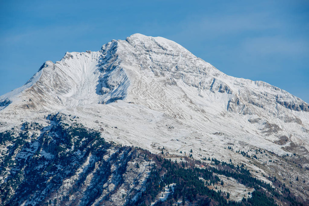 der schneebedeckte Berg Arera erscheint aus den Wolken - Foto, Bild