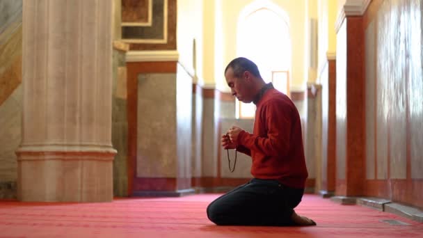 Muslimský muž uctívání s modlitební korálky nebo růženec v mešitě - Záběry, video