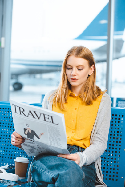 attractive woman reading travel newspaper in departure lounge - 写真・画像