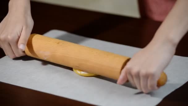 Les mains féminines roulent la pâte avec un rouleau à pâtisserie, faisant gâteau au miel
. - Séquence, vidéo