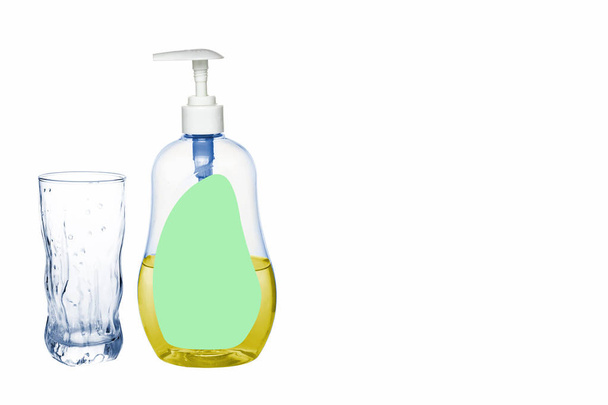 Plastic bottle of detergent stands next to a glass cup on a white background, isolate - Foto, Imagen