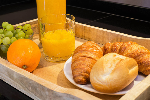 aamiainen tarjotin appelsiinimehu croissantteja ja hedelmiä
 - Valokuva, kuva