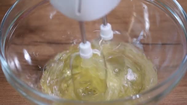 Verte tojást fehérjék az üveg tálba. Folyamat a korbácsolás fehérjék a keverő tálba elektromos keverővel. - Felvétel, videó
