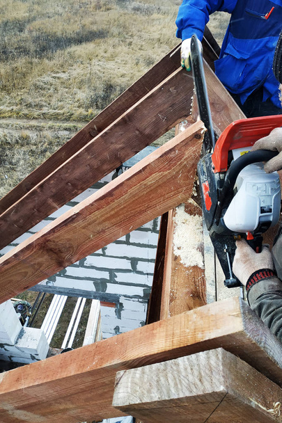 Workers cut the rafters on the roof of the chainsaw house 2019 - Photo, Image