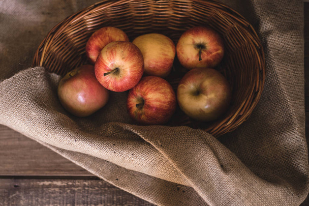 freshly picked apples in a wicker basket - Foto, afbeelding