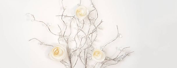 White paper Roses on silver branches on white background. Flat lay, top view. Valentines Day background - Fotó, kép