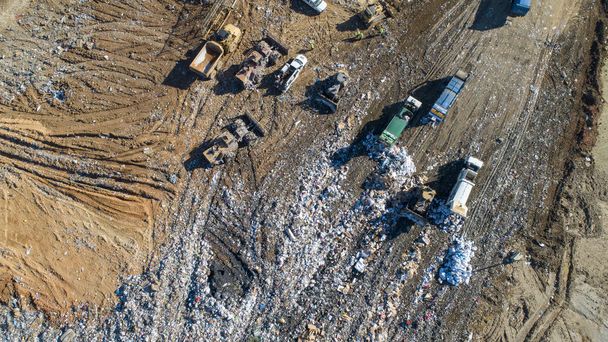 Aerial views of a county trash dump being serviced by multiple dump trucks - Photo, Image