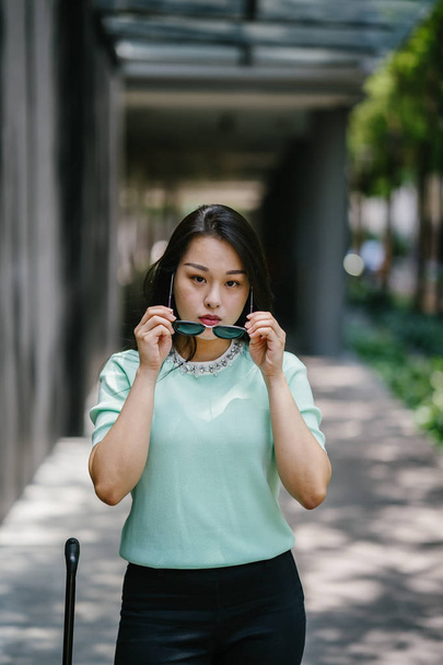 Portrait of a young, sexy and glamorous Asian woman during the day. She is wearing a mint green sweater - Fotó, kép
