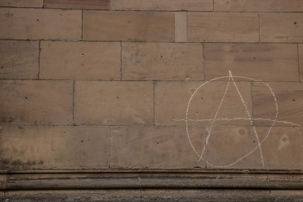 Vecchio muro di un edificio storico con scritto segno di anarchia
 - Foto, immagini