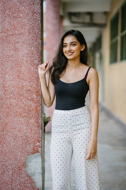 portrait of a young, attractive and beautiful Indian Asian girl in fitting black top - Valokuva, kuva