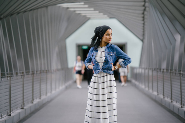 Young, elegant and attractive Malay Muslim woman wearing dress and denim jacket during the day. - Фото, изображение