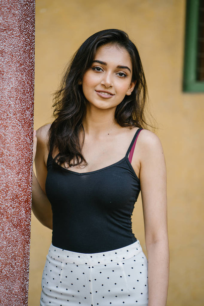 portrait of a young, attractive and beautiful Indian Asian girl in fitting black top - Zdjęcie, obraz