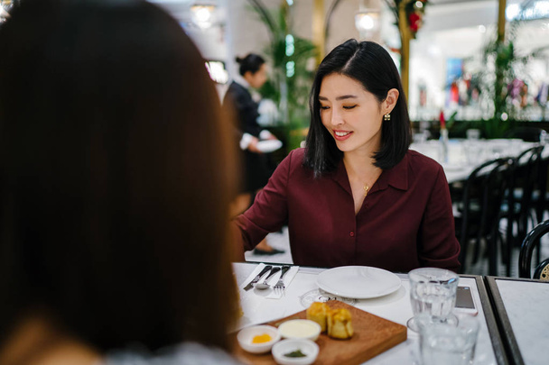 portrait of a beautiful and elegant young Korean Asian woman sitting in a classy indoors cafe - Foto, imagen