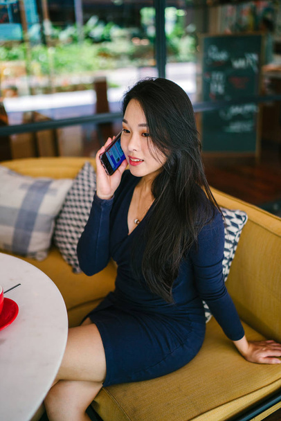 Portré egy fiatal és gyönyörű ázsiai kínai nő beszél okostelefonon - Fotó, kép