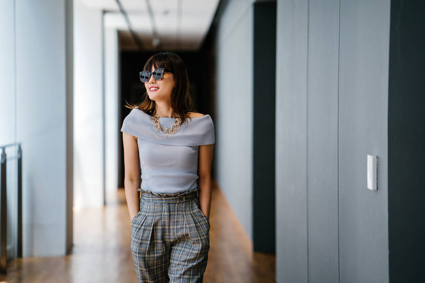 Portrait of a middle-aged, mature Asian Chinese woman in smart casual grey outfit - Foto, afbeelding