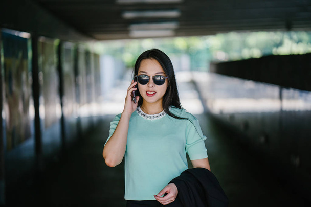 Portrait of a young and beautiful Asian Chinese woman talking on smartphone - 写真・画像