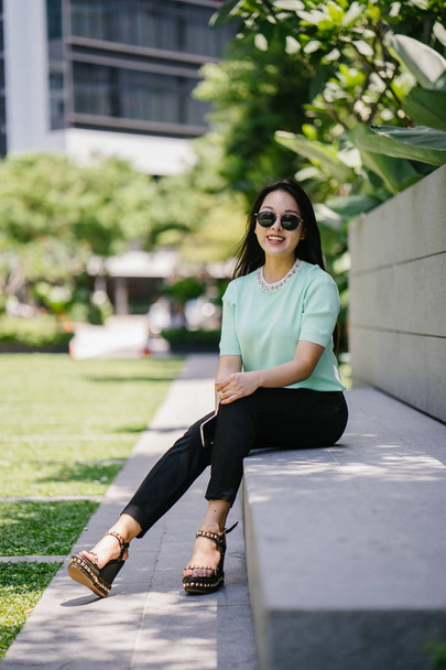 Portrait of a young, sexy and glamorous Asian woman during the day. She is wearing a mint green sweater - Foto, immagini