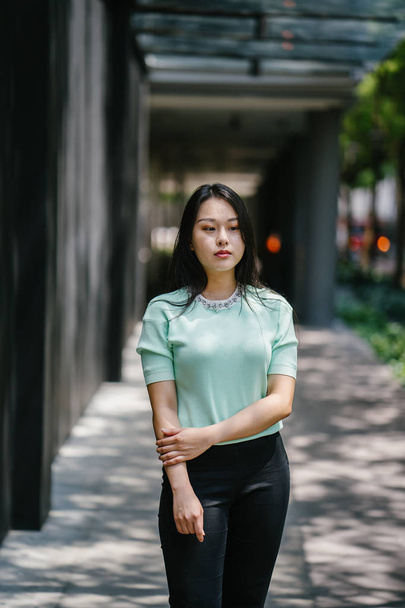 Portrait of a young, sexy and glamorous Asian woman during the day. She is wearing a mint green sweater - Foto, Bild