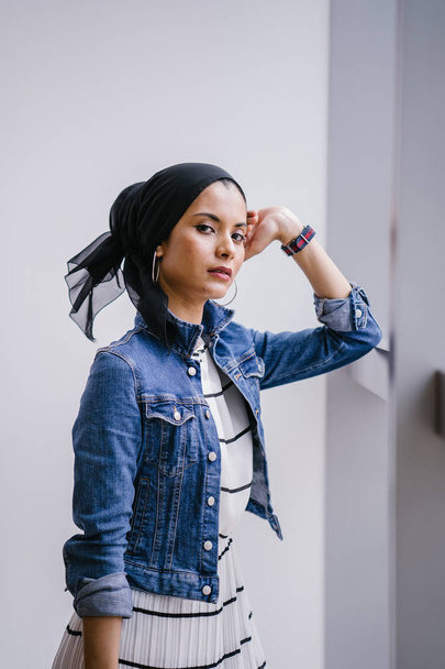 Young, elegant and attractive Malay Muslim woman wearing dress and denim jacket during the day. - Photo, Image