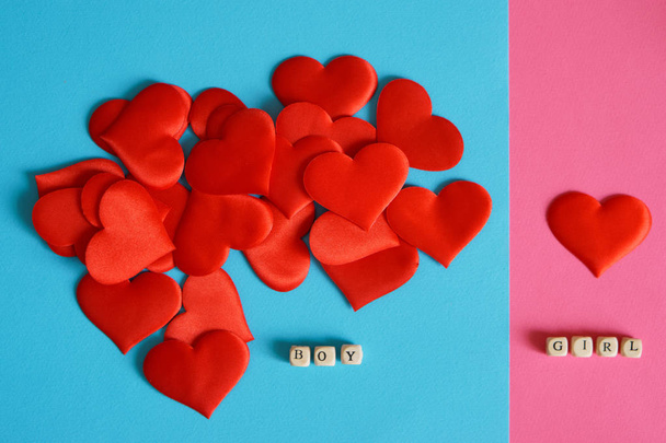 Coeurs rouges sur une surface bleue et rose. L'amour et les différences de genre. Le ratio garçons / filles. Félicitations pour la Saint-Valentin
.                                - Photo, image