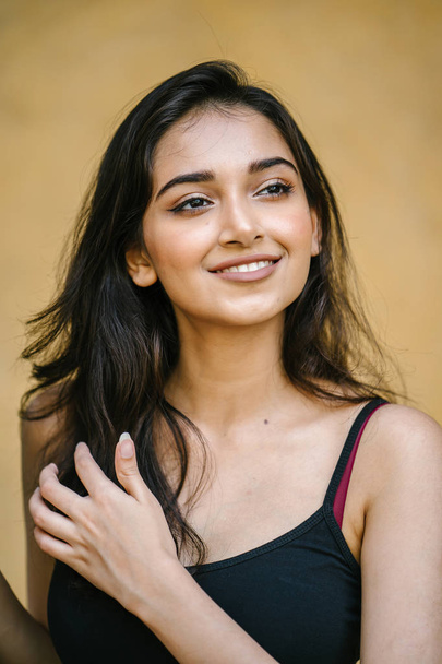 portrait of a young, attractive and beautiful Indian Asian girl in fitting black top - Foto, afbeelding