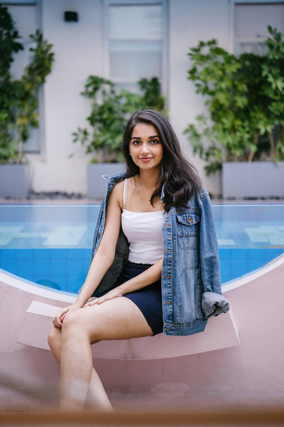Portrait of a beautiful, young and attractive Indian Asian woman in a white top, blue skirt and denim jacket. - Foto, afbeelding