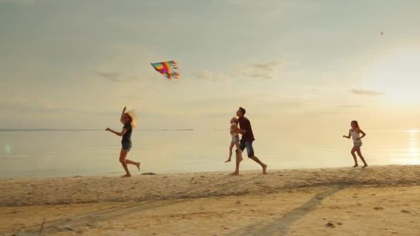 Mum plays with children kite. Children have fun and carefree running on the beach. - Footage, Video