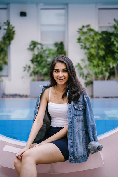 Portrait of a beautiful, young and attractive Indian Asian woman in a white top, blue skirt and denim jacket. - Zdjęcie, obraz