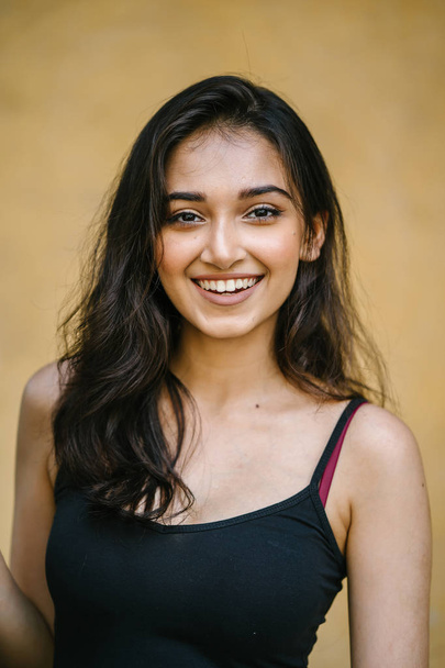 portrait of a young, attractive and beautiful Indian Asian girl in fitting black top - Zdjęcie, obraz