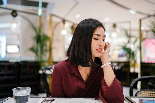 portrait of a beautiful and elegant young Korean Asian woman sitting in a classy indoors cafe - Foto, Imagem
