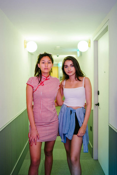 young Asian girl friends posing in a narrow corridor walkway - Foto, imagen