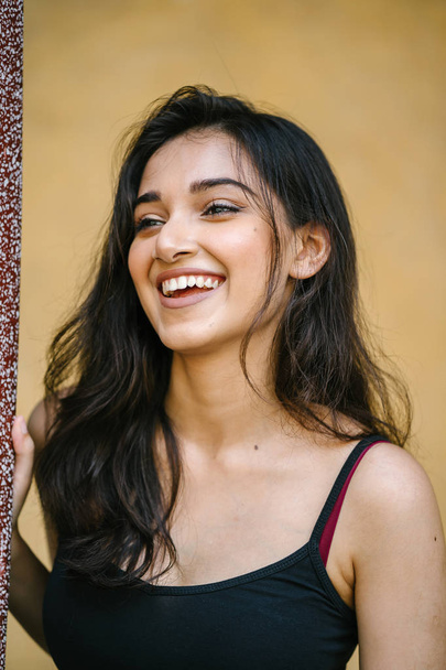 portrait of a young, attractive and beautiful Indian Asian girl in fitting black top - Foto, Imagen
