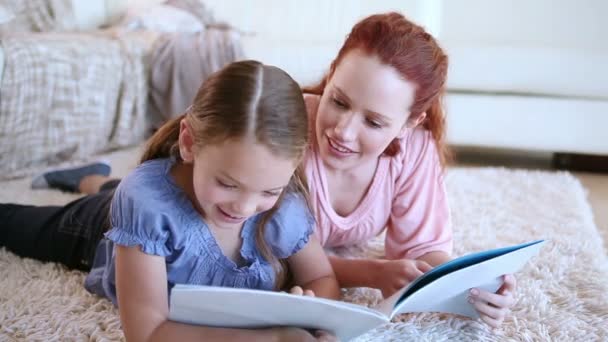 słodkie dziecko czytając książkę na głos z matką - Materiał filmowy, wideo