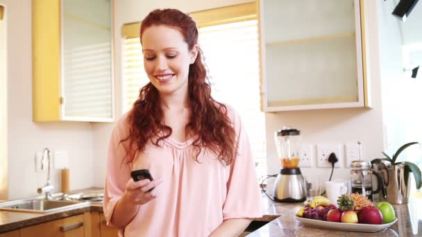 Smiling woman sending a text - Metraje, vídeo