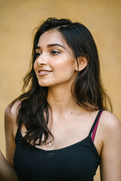 portrait of a young, attractive and beautiful Indian Asian girl in fitting black top - Photo, Image