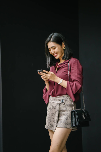 young Korean Asian woman holding smartphone  - Photo, image